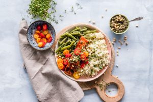 Gesunde, selbst gekochte Mahlzeit mit Bulgur, Lachs, Bohnen, Tomaten und einem Pesto mit Pinienkernen