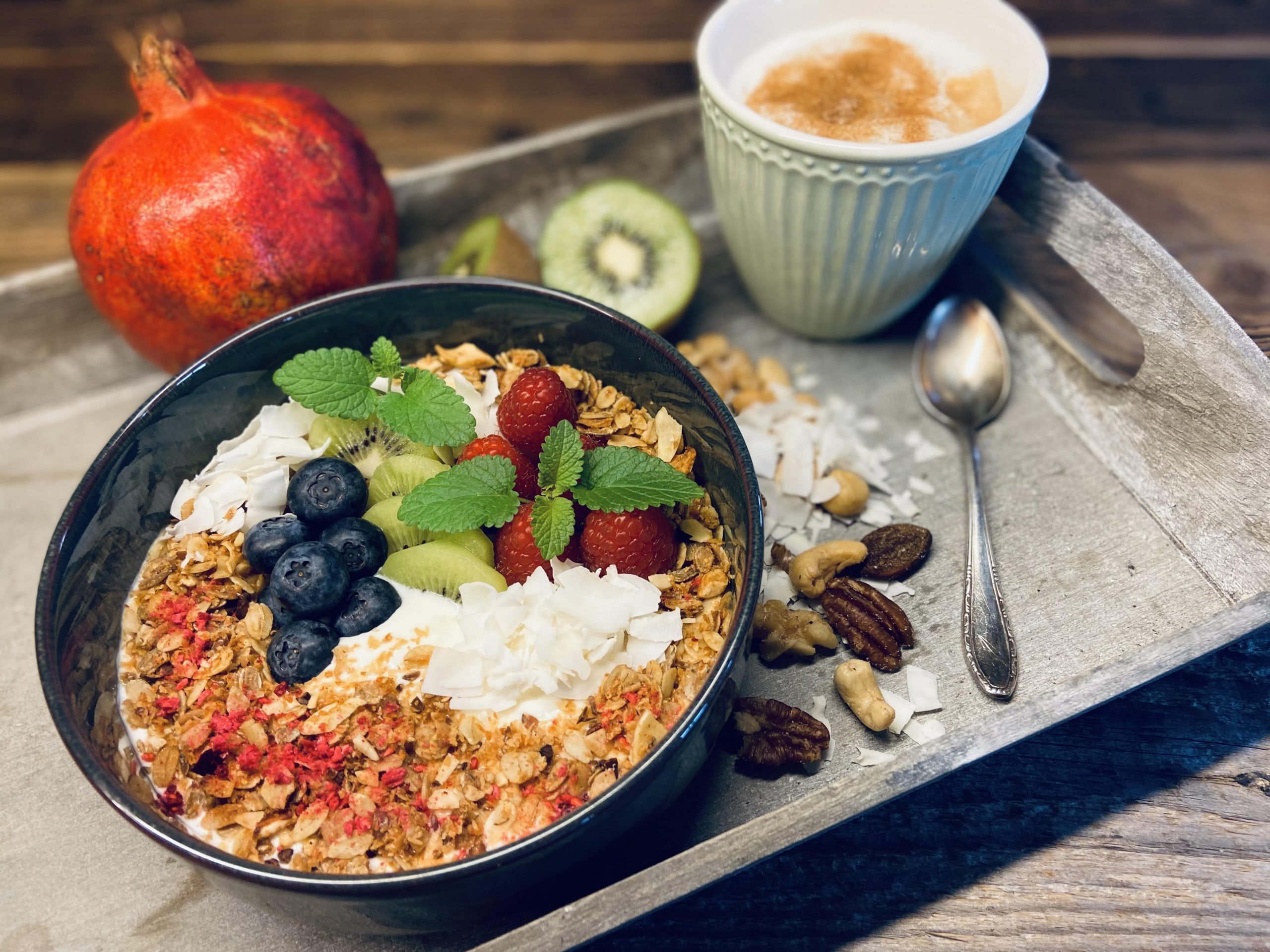 Nuss Granola mit Kokos Chips in Schüssel auf Tablett