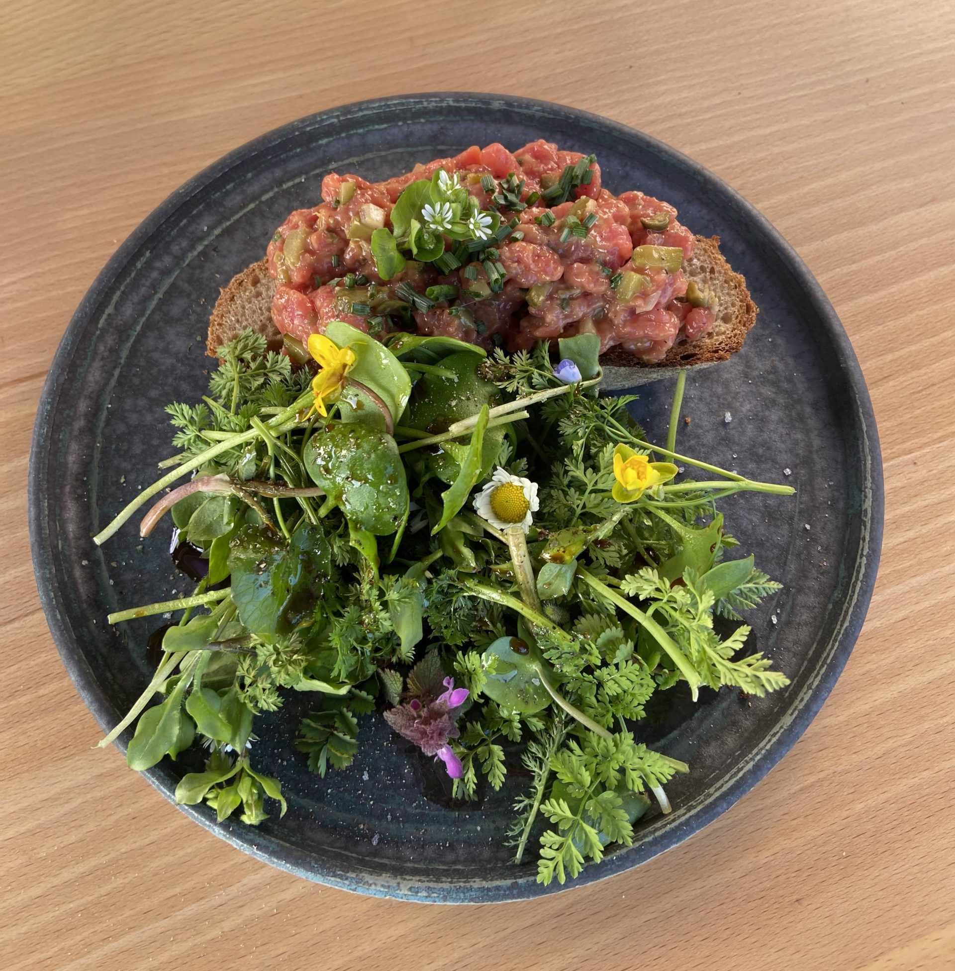 Rindertartar mit karamellisierten Nüssen auf Brot mit Salat