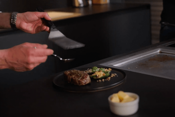 Rinderfilet mit Tomatensalat auf Teller anrichten