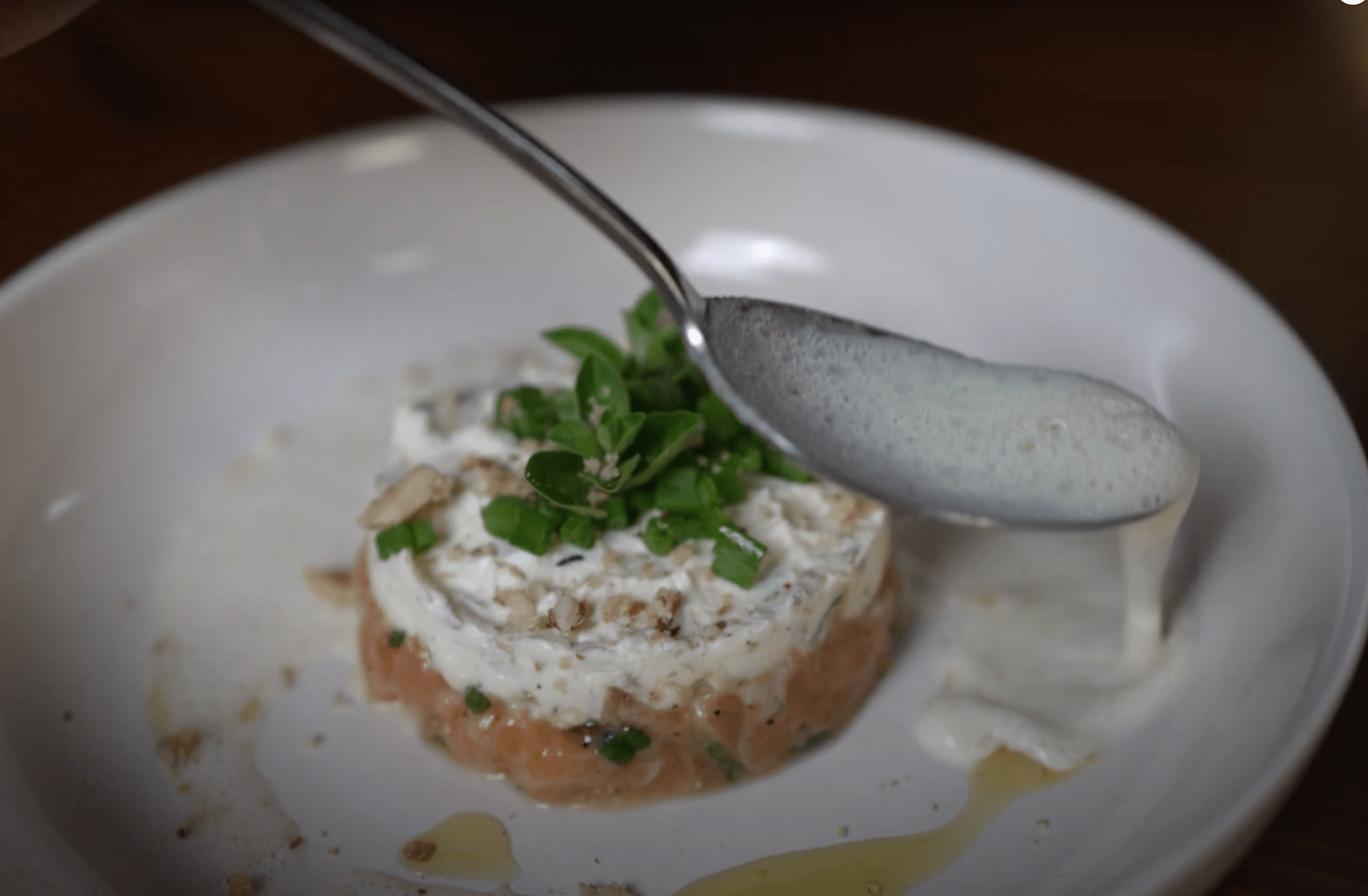 Lachstartar mit Frischkäse und Löffel auf Teller