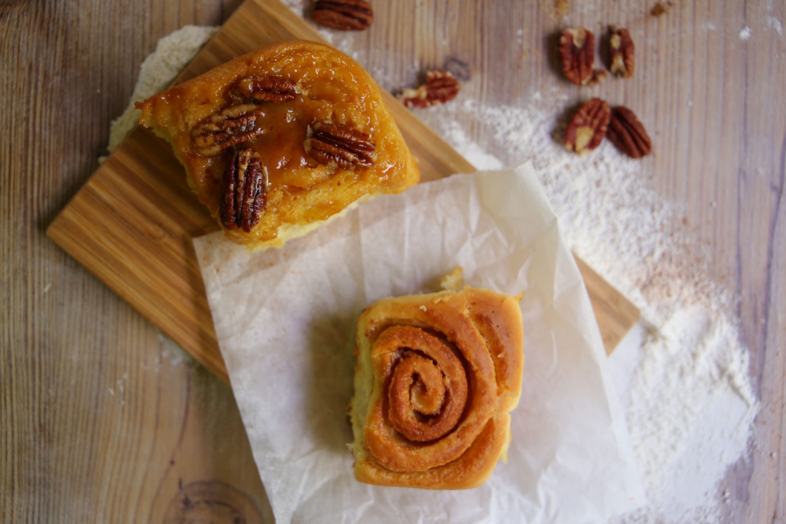 Sticky Buns mit Pekannüssen auf Holzbrett