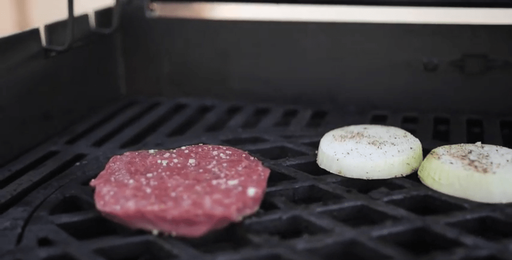 Burger Patty und Zwiebeln auf Grill